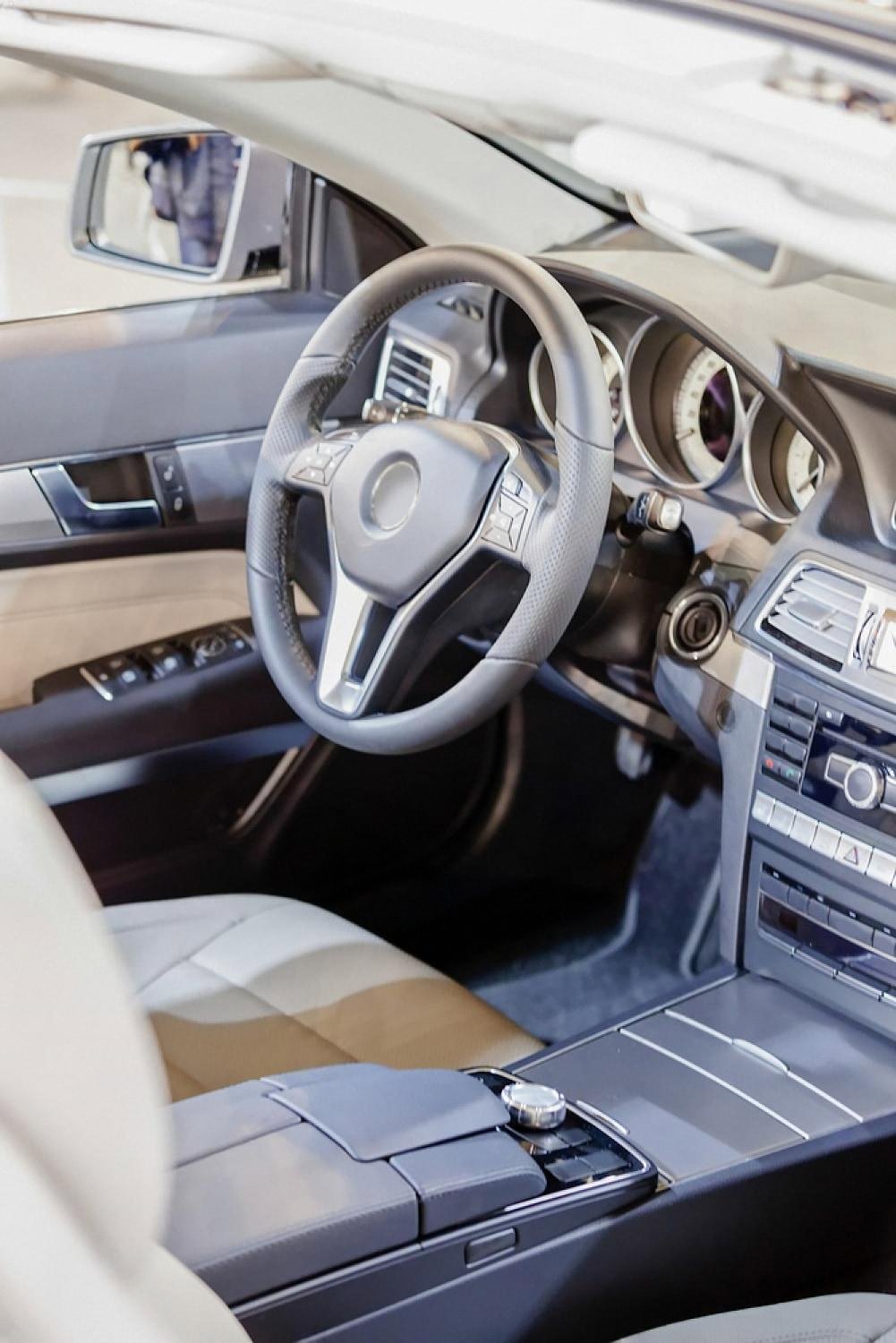Clean leather car interior with polished steering wheel and dashboard